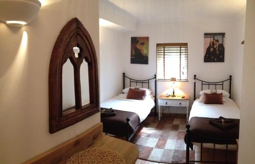 a room with two beds and a mirror in it at Tanglewood Gatwick Bed & Breakfast in Crawley
