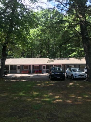 a building with two cars parked in front of it at Elmwood Motor Court in Old Orchard Beach