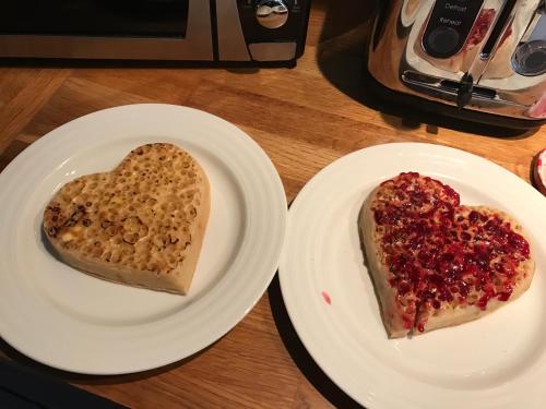 two white plates with a piece of bread with a heart on it at The Brewster Inn in Dexter