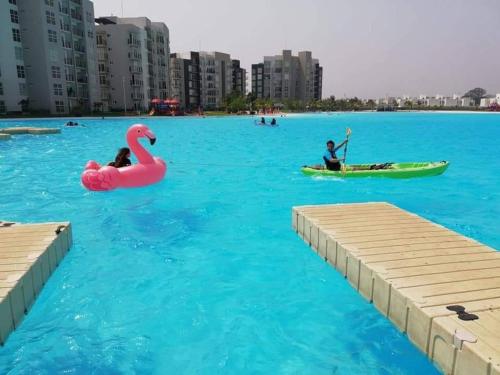 two people in a pool with a pink flamingo in the water at Casa con alberca y laguna in Veracruz