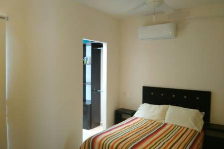 a bedroom with a bed with a striped blanket at Casa con alberca y laguna in Veracruz