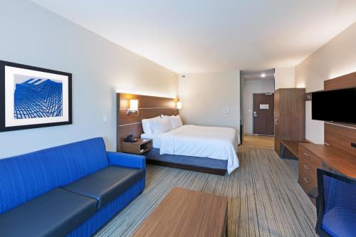 レネックサにあるHoliday Inn Express & Suites - Lenexa - Overland Park Area, an IHG Hotelのベッドとソファ付きのホテルルーム
