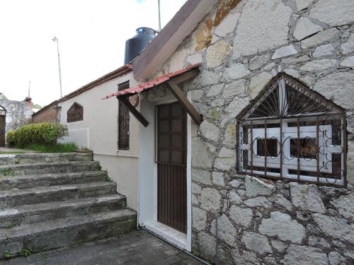 a stone building with a window and stairs at Cabañas- Casas España in Mineral del Chico