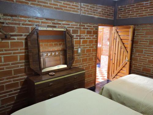 a bedroom with two beds and a brick wall at Cabañas- Casas España in Mineral del Chico