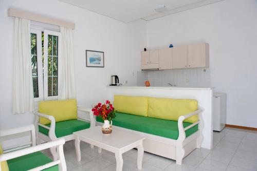 una sala de estar con 2 sofás amarillos y verdes y una mesa. en Samos Apartments, en Marathokampos