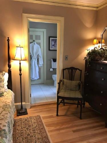a bedroom with a dresser and a robe hanging on a door at The Brewster Inn in Dexter