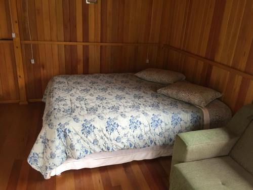 a bedroom with a bed with a blue and white comforter at Cantinho do Sossego in Urubici
