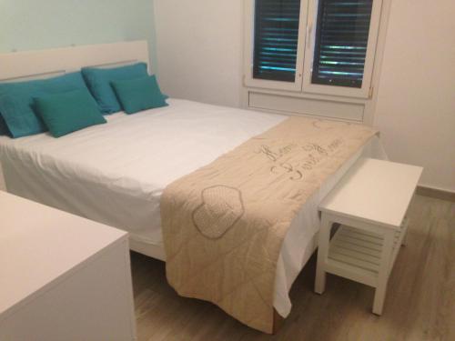 een slaapkamer met een wit bed met blauwe kussens bij Bungalow Playa del Inglés centre in Playa del Inglés