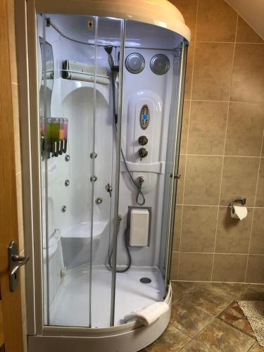 a shower with a glass door in a bathroom at Cois Na Tra in Spanish Point