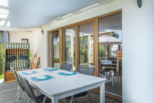 een eetkamer met een witte tafel en stoelen bij Osada Dębki in Dębki