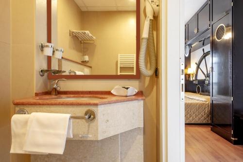 ein Bad mit einem Waschbecken und einem Spiegel in der Unterkunft Hotel Villa Lo Scoglietto in San Vincenzo