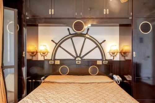 a bed in a room with a large wooden wheel at Hotel Villa Lo Scoglietto in San Vincenzo