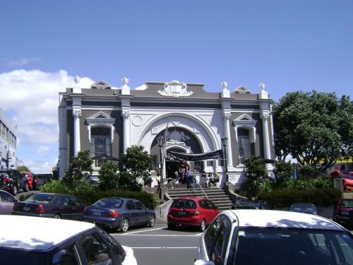 a large building with cars parked in front of it at Harbour View Cottage in Auckland