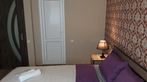 a bedroom with a bed and a door with a lamp at MANGO Guesthouse in Sighnaghi