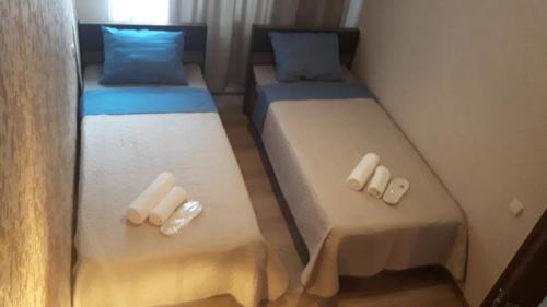 two twin beds in a small room with towels at MANGO Guesthouse in Sighnaghi