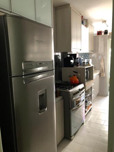 a kitchen with a stainless steel refrigerator and a stove at Apto continente Florianópolis in Florianópolis