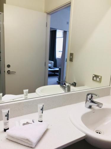 a bathroom with two sinks and a large mirror at Quest On Lambton Serviced Apartments in Wellington