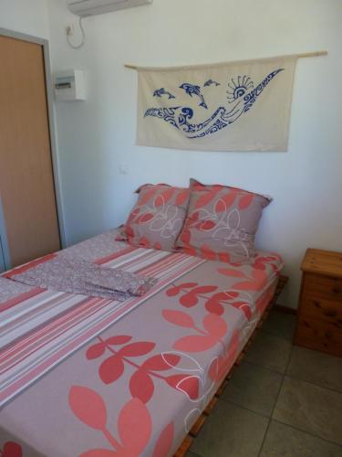 Schlafzimmer mit einem Bett mit roten und rosa Kissen in der Unterkunft Farehani 2 in Avatoru
