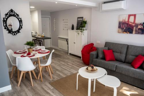 uma sala de estar com um sofá, uma mesa e cadeiras em Apartamento Valtour Valladolid em Valladolid