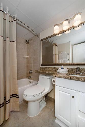 a bathroom with a toilet and a sink and a mirror at Casa Del Mar Beach View in Galveston