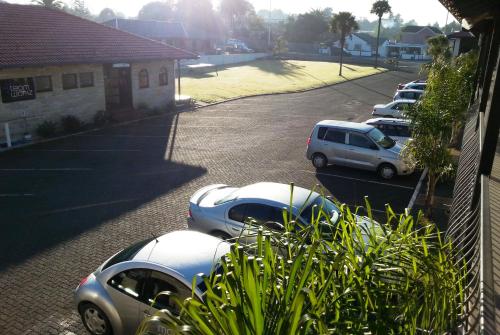 a row of parked cars parked in a parking lot at Motel Sierra in Whangarei