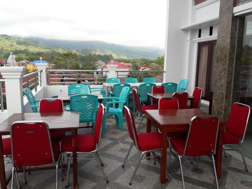 una fila de mesas y sillas en un balcón en Toraja Lodge Hotel en Rantepao