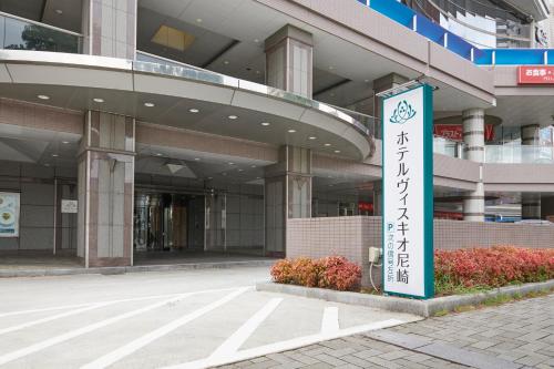 尼崎的住宿－HOTEL VISCHIO AMAGASAKI by GRANVIA，前面有标志的建筑
