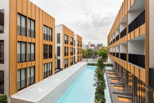 an apartment complex with a swimming pool between two buildings at Craftsman Bangkok in Bangkok