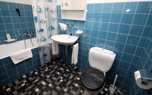 サンモリッツにあるAllod Bad 508の青いタイル張りのバスルーム(トイレ、シンク付)