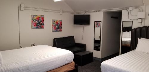 a hotel room with two beds and a chair at Deep Water Inn in Chelan