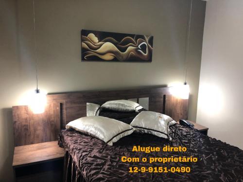 a bedroom with a bed with two pillows on it at Aldeia das Águas Park-Flat Quartier Luxo in Barra do Piraí