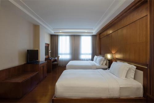 ein Hotelzimmer mit 2 Betten und einem TV in der Unterkunft Nhat Ha L’Opera Hotel in Ho-Chi-Minh-Stadt
