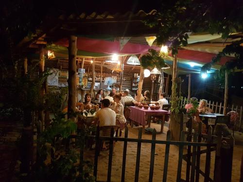 a group of people sitting at a restaurant at night at Margarita Village kite school kalpitiya in Kalpitiya