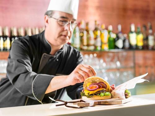 a chef is preparing a sandwich on a counter at Novotel Brussels City Centre in Brussels