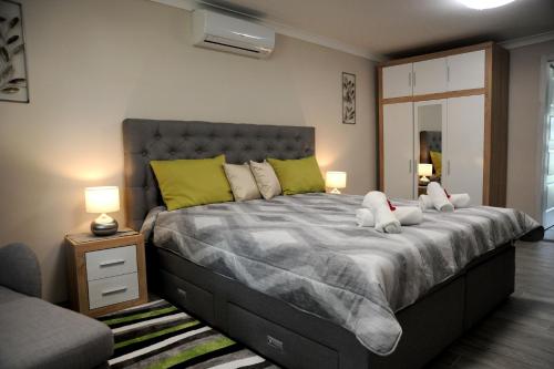 una camera da letto con un grande letto con due peluche sopra di Judit Apartman Dombóvár-Gunaras a Dombóvár