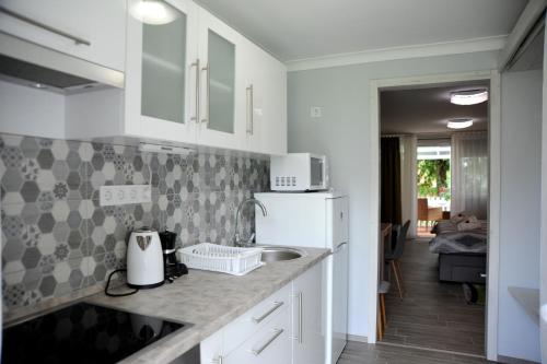 a kitchen with a sink and a white refrigerator at Judit Apartman Dombóvár-Gunaras in Dombóvár