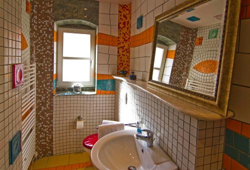 ein Bad mit einem Waschbecken und einem Spiegel in der Unterkunft Art Apartments in Dresden