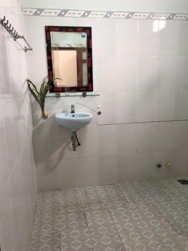 a bathroom with a sink and a mirror on the wall at Bí Homestay in Mui Ne