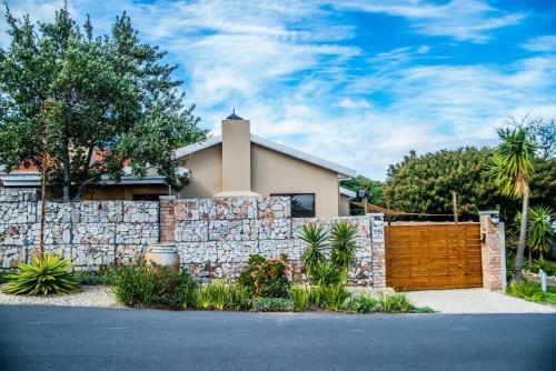 a stone fence in front of a house at 16 On Antrim in Hermanus