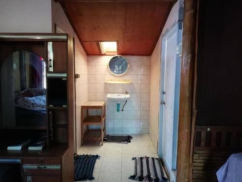 Baño pequeño con lavabo y espejo en Chian Guesthouse, en Chiang Rai