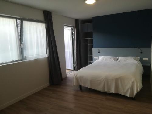 a bedroom with a white bed and a large window at Atao Residence- Rennes Sud in Vern-sur-Seiche