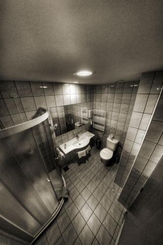 a bathroom with a sink and a toilet and a tub at Hotel Lav Vukovar in Vukovar