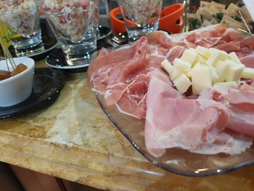 a plate of meat and cheese on a table at Hotel I Narcisi in Siniscola