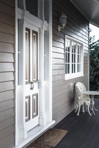 a front door of a house with a bench on a porch at The Ark Stanley Luxury Bed and Breakfast in Stanley
