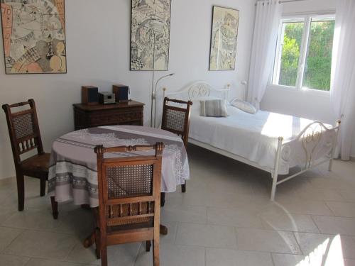Laroque-des-AlbèresにあるLe Quatorzeのベッドルーム1室(ベッド2台、テーブル、椅子付)