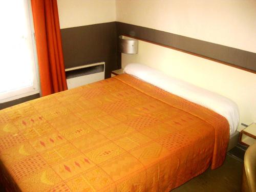 een slaapkamer met een bed met een oranje deken bij Hôtel du Pont Neuf in Parijs