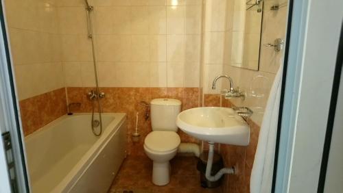 a bathroom with a toilet and a sink and a tub at семеен хотел "НЕВЕН" in Momin Prohod