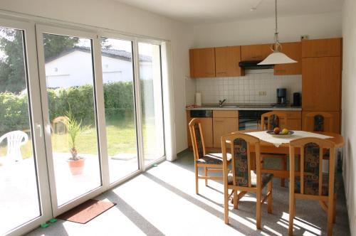 a kitchen with a table and a dining room with sliding glass doors at Haus Galerie EG in Karlshagen