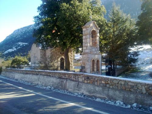 a church on a wall next to a road at Hani Zemenou in Arachova