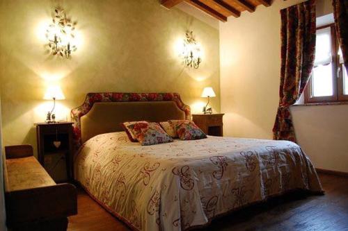 ein Schlafzimmer mit einem Bett mit zwei Lampen und einem Fenster in der Unterkunft Il Podere Bellavista in Montecatini Val di Cecina